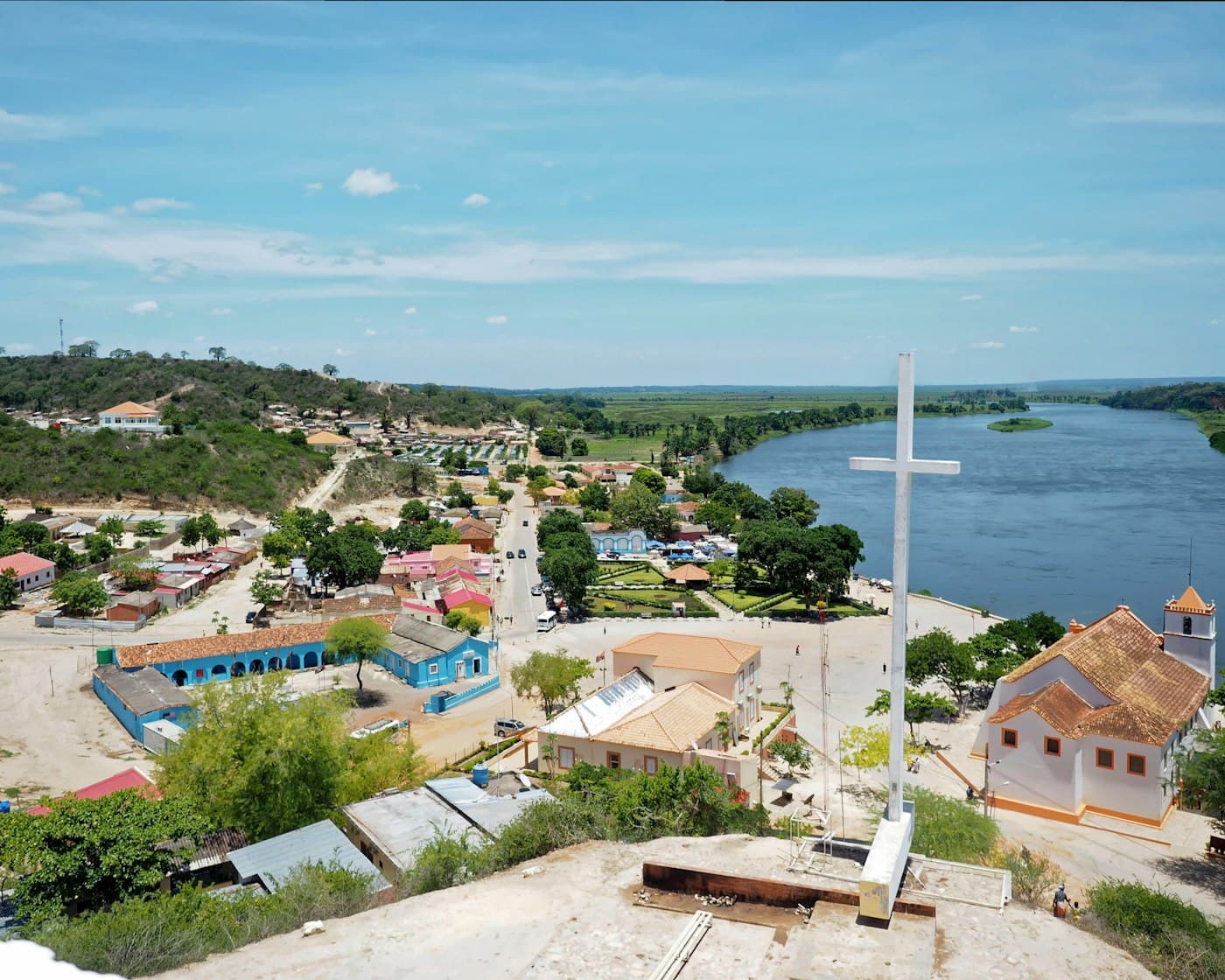 Vista aérea da Muxima, com a grande cruz branca, a igreja e o rio ao fundo